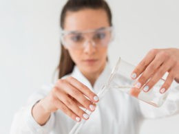 Front view of female scientist with safety glasses and potions