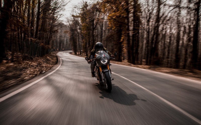 Biking a motorcycle in the forest.