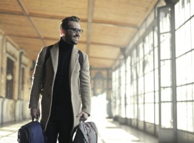 Man in Brown Robe Carrying Bag Smiling