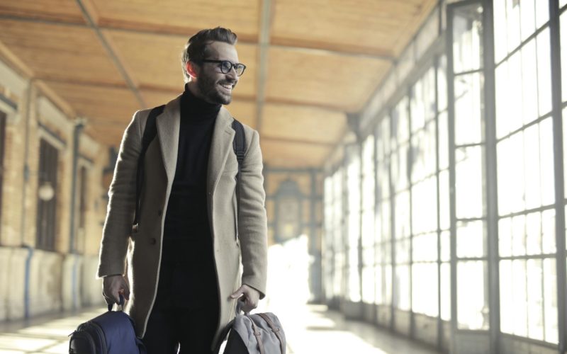 Man in Brown Robe Carrying Bag Smiling