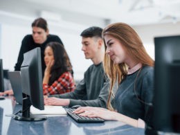 Computer screens. Group of young people in casual clothes working in the modern office