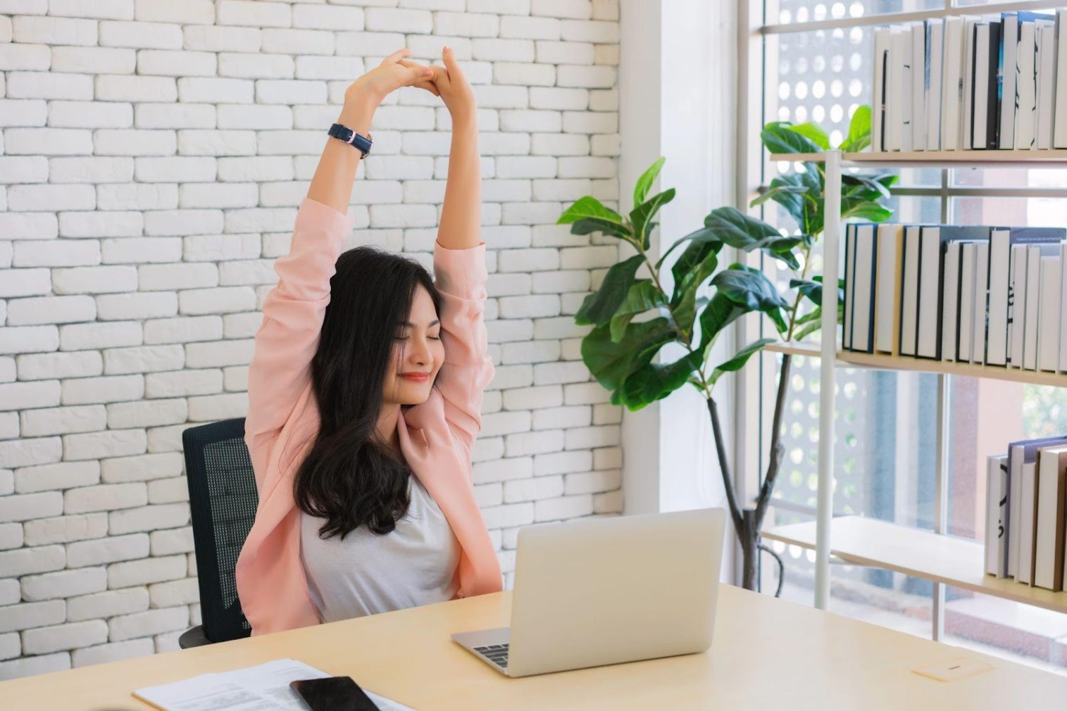 Business woman work from home and stretching her body because feel tired after working on tablet computer,