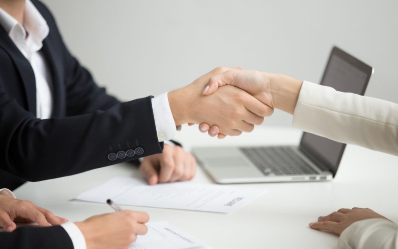 Hr handshaking successful candidate getting hired at new job