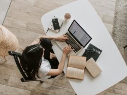 Young lady typing on keyboard of laptop in living room