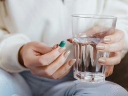 Woman Holding Pill and Glass of Water