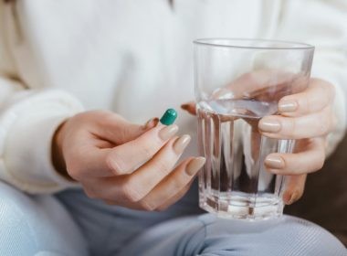 Woman Holding Pill and Glass of Water