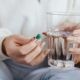 Woman Holding Pill and Glass of Water