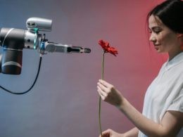 A Smiling Woman in White Shirt Holding a Red Flower