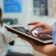 Close up of nurse holding and typing on tablet