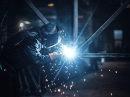 Welding work with metal construction at busy metal factory