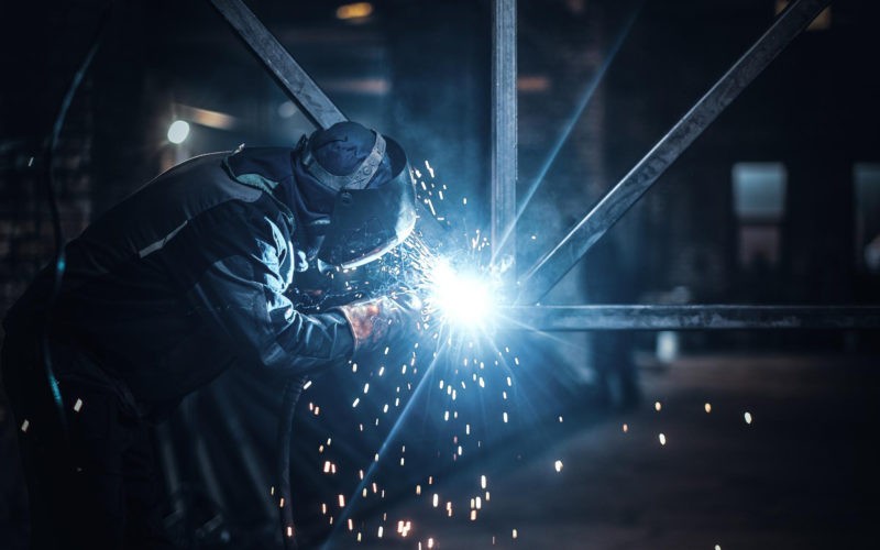 Welding work with metal construction at busy metal factory