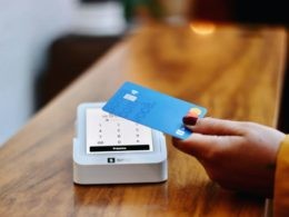 a person holding a credit card in front of a machine
