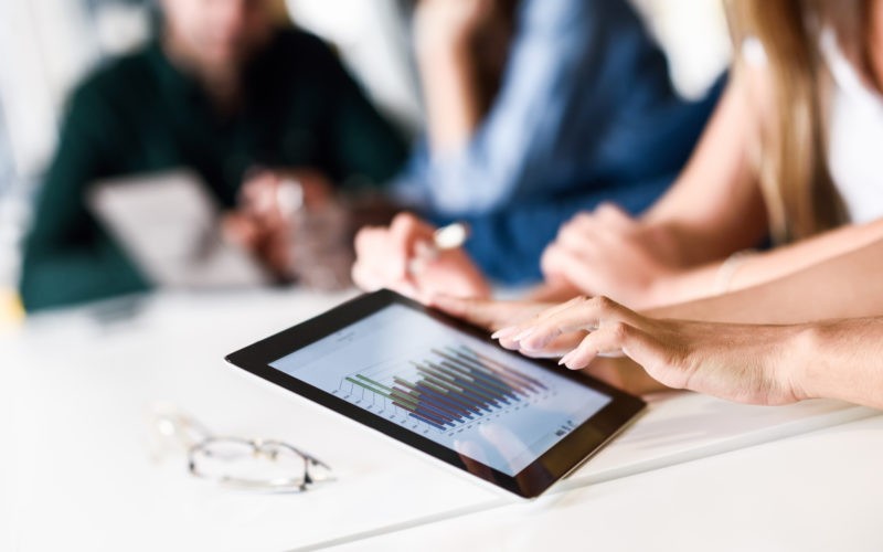 Group of young men and woman coworking with tablet computer