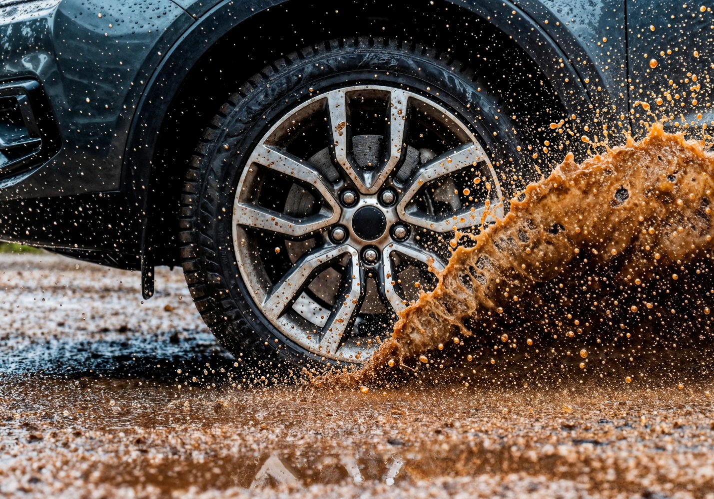 Car wheel splashing through mud