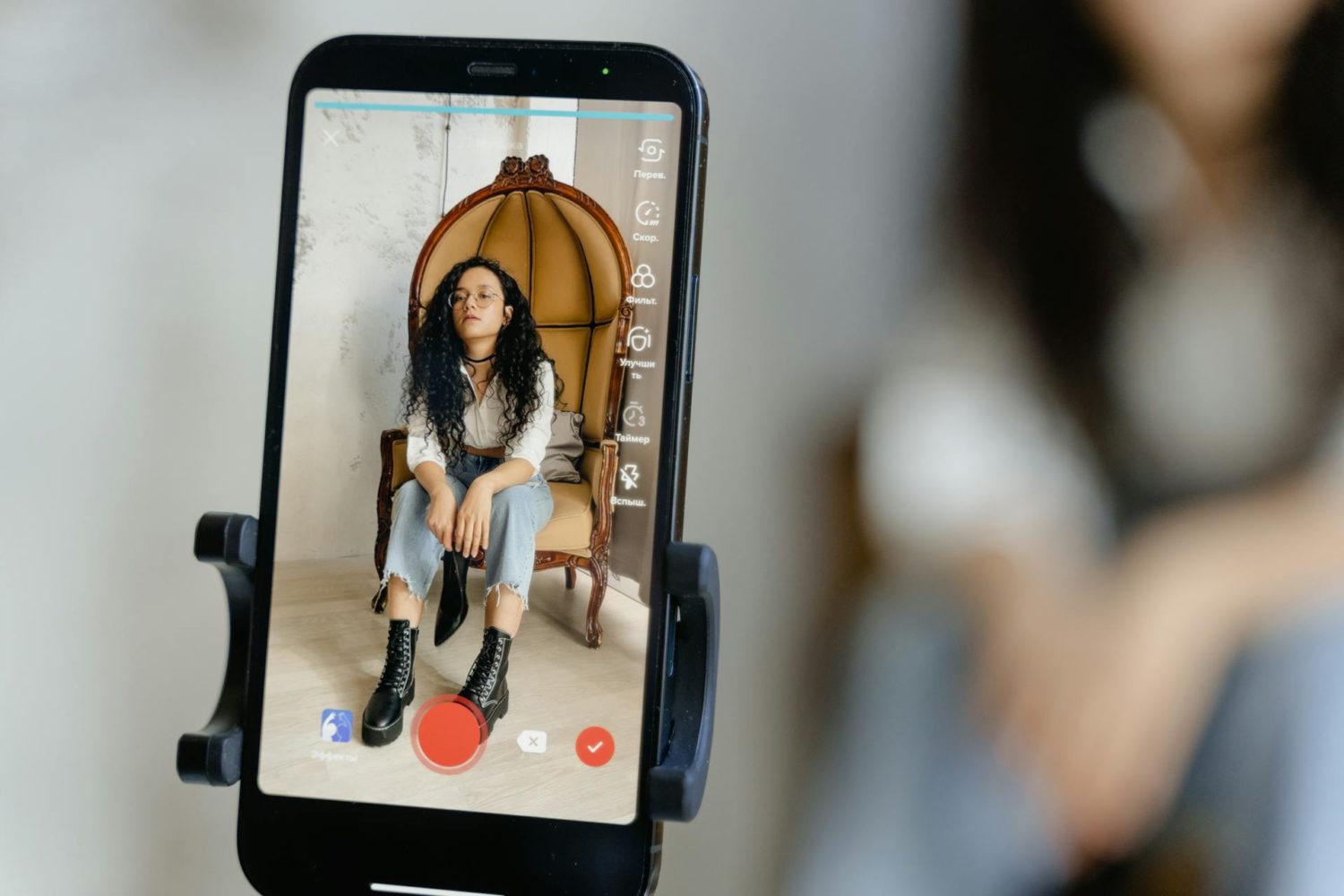 a Smartphone Recording a Woman Sitting on a Chair
