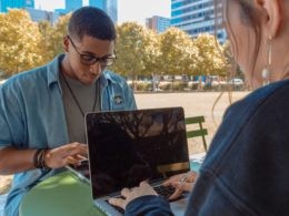 man and woman sitting while using MacBook Pro