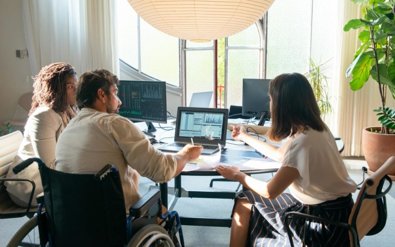 Colleagues Talking Near a Laptop with Charts
