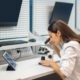 Woman sitting at table looking through microscope