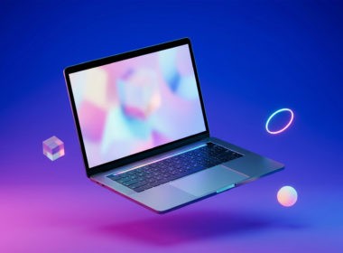 A modern laptop floating in mid-air against a vivid blue-and-magenta gradient, surrounded by geometric objects.