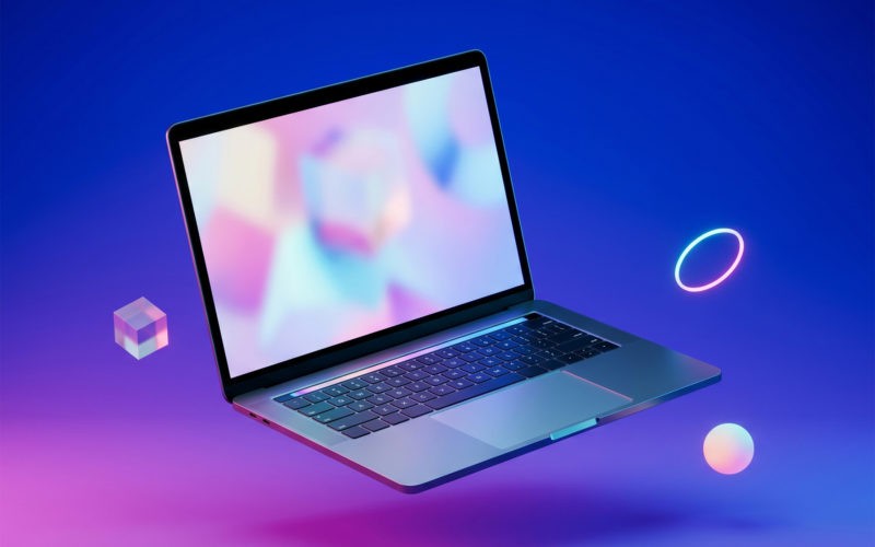 A modern laptop floating in mid-air against a vivid blue-and-magenta gradient, surrounded by geometric objects.
