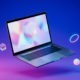 A modern laptop floating in mid-air against a vivid blue-and-magenta gradient, surrounded by geometric objects.