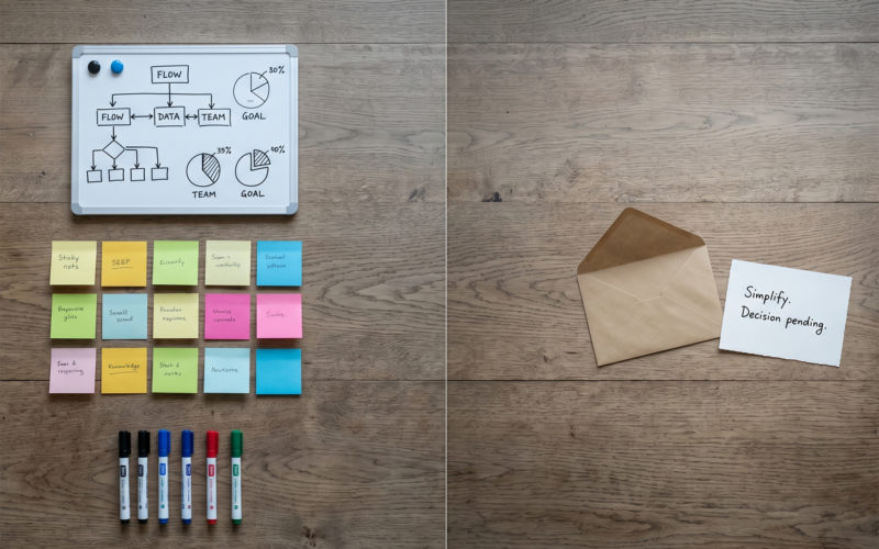 Overhead view of a desk split between structured internal team tools and a lone outreach letter representing the gap in external communication