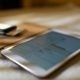 Close-up of a tablet displaying financial graphs on a soft white surface, ideal for business concepts.