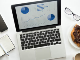 Open laptop with a diagram on, glasses, mobile, office supplies