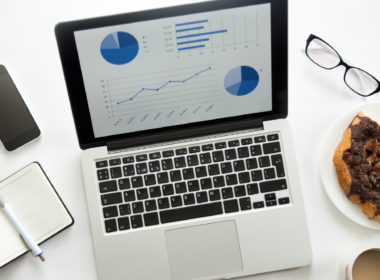 Open laptop with a diagram on, glasses, mobile, office supplies