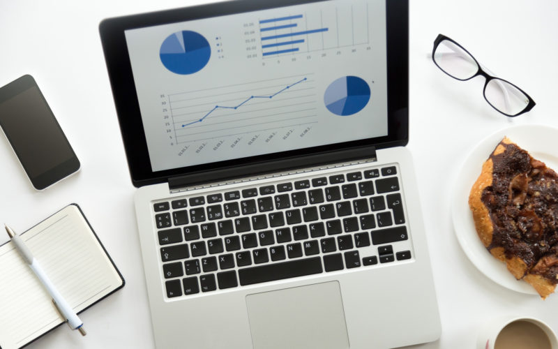 Open laptop with a diagram on, glasses, mobile, office supplies