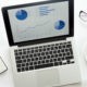 Open laptop with a diagram on, glasses, mobile, office supplies